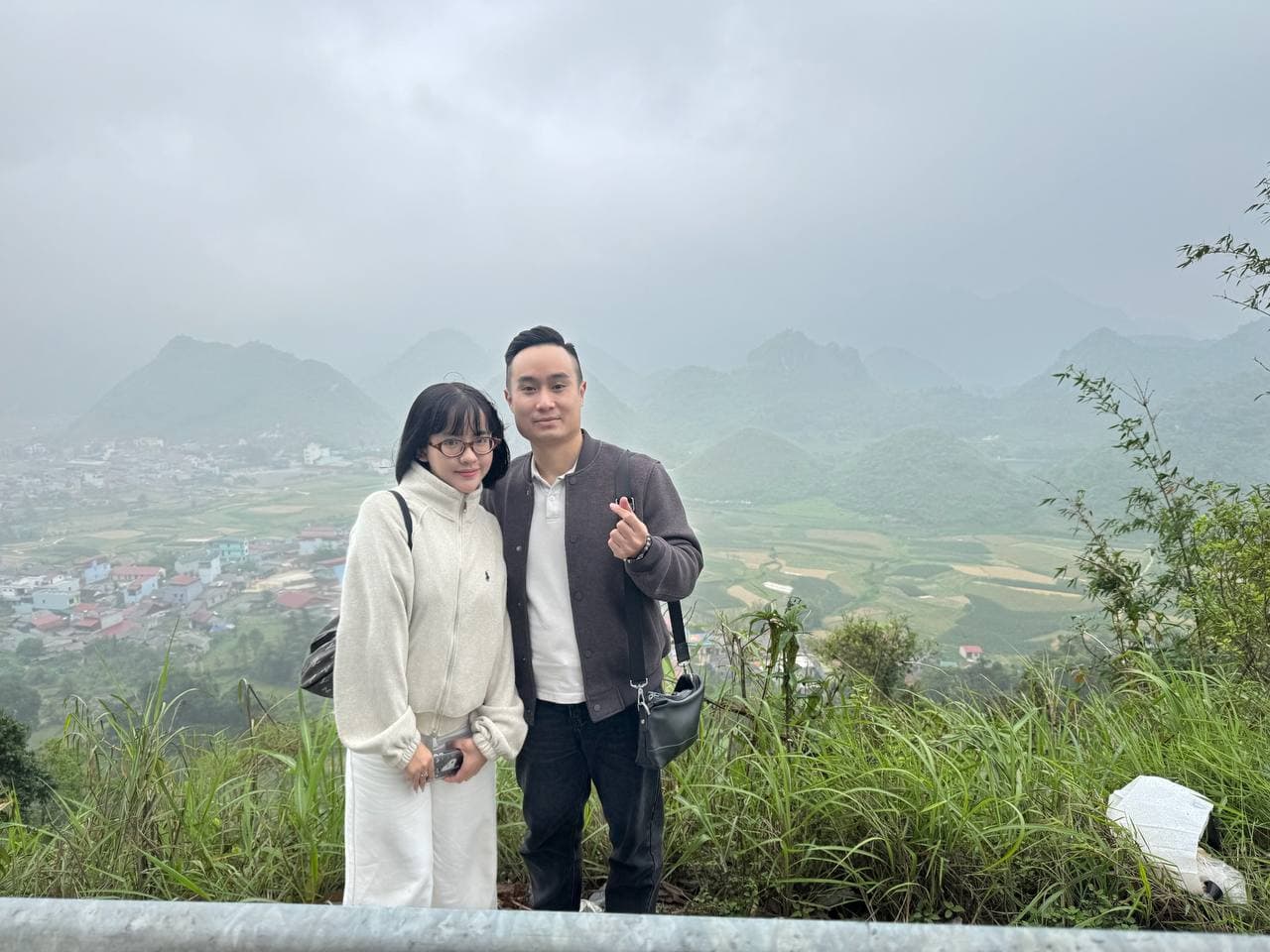 Hai người trước Núi Đôi Quản Bạ trong sương